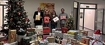 Sternschnuppenaktion 2025 Vier Menschen im Vordergrund bei der Übergabe von Geschenken,