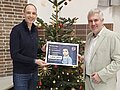 Sternschnuppenaktion 2025 Zwei Personen stehen vor einem Weihnachtsbaum und übergaben einen Scheck