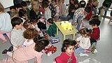 Sternschnuppenaktion 2025 Viele Kinder sitzen auf dem Boden und packen Geschenke aus