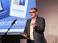 Hochschultag 2025 Keynote-Speaker Thilo Baum steht auf der Bühne an einem Rednerpult.