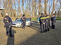 Internationaler Austausch Mehrere Polizisten stehen draußen bei Herbstwetter um ein Auto herum.