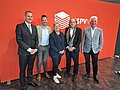 Personalmanagement in neuen Zeiten Mehrere Personen für ein Gruppenfoto vor einer orangenen HSPV-Wand.