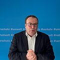 Verkehrsexpertentag 2025 Oliver Krischer vor blauem Hintergrund in einer Videobotschaft.