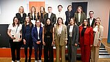 Die Graduierten stehen auf einer Bühne. Hinter ihnen ist das Logo der HSPV NRW zu sehen.