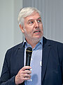 Prof. Dr. Christof Muthers mit einem Mikrofon in der Hand.