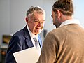 NRW-Innenminister Herbert Reul schüttelt einem jungen Mann, der von hinten zu sehen ist, die Hand.